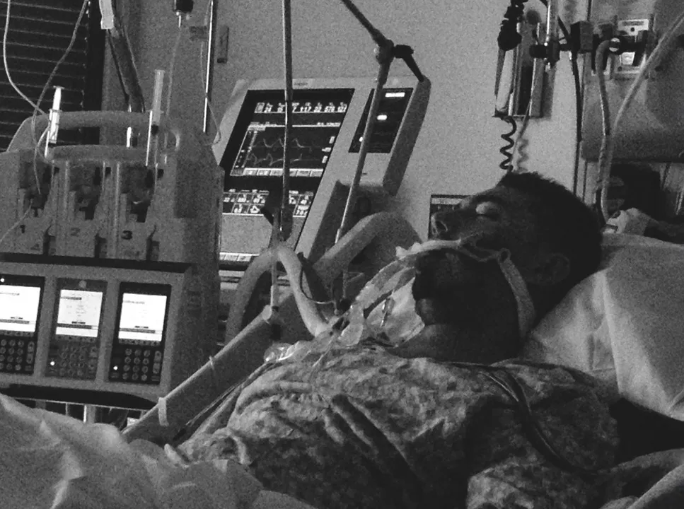 Brian Ballah on a ventilator in intensive care during the illness that nearly took his life.